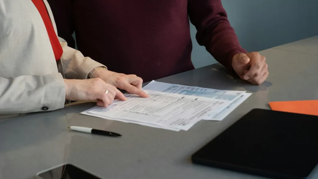 Two people reviewing Medicaid application forms at a table